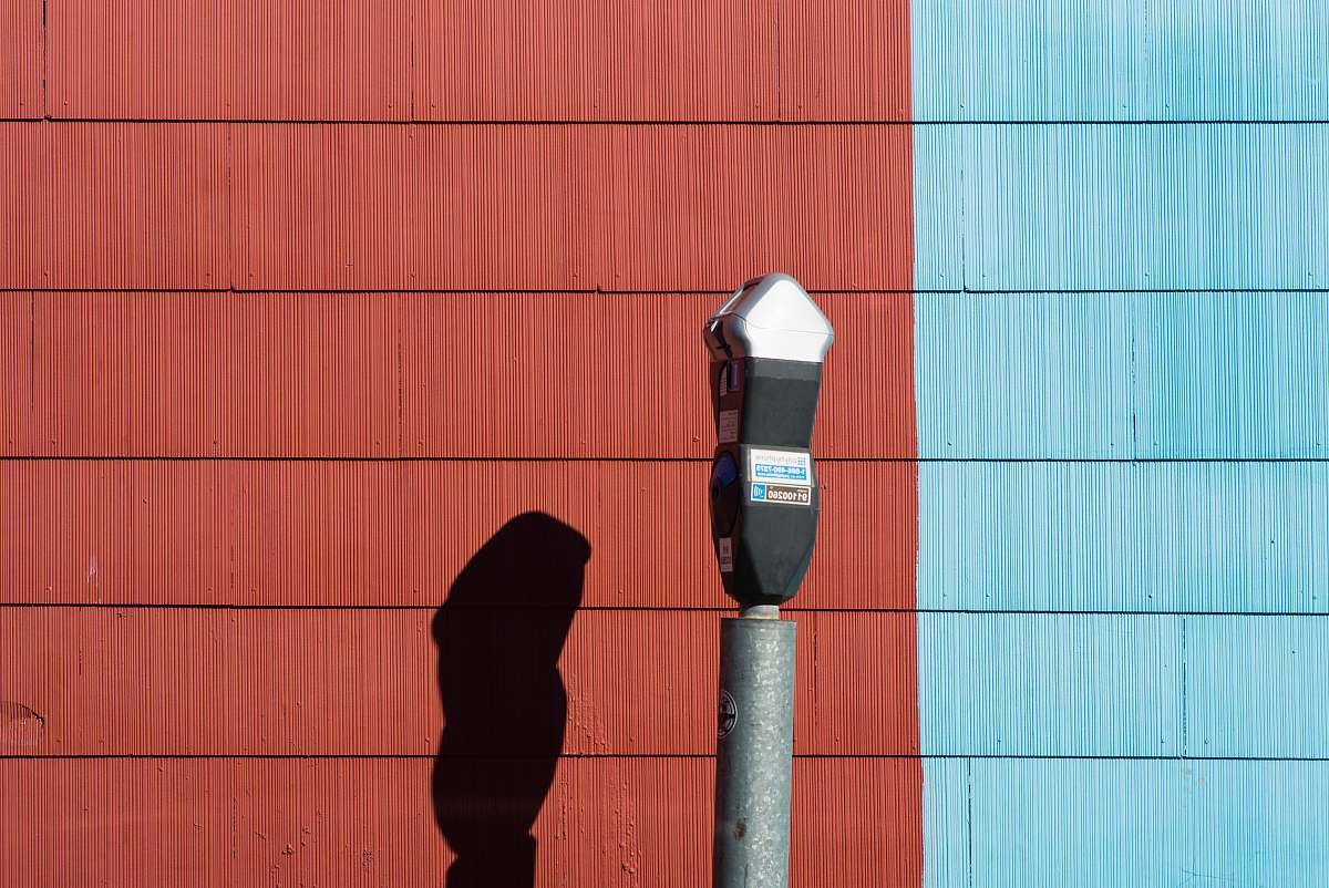 parking lot park meter beside wall parking meter